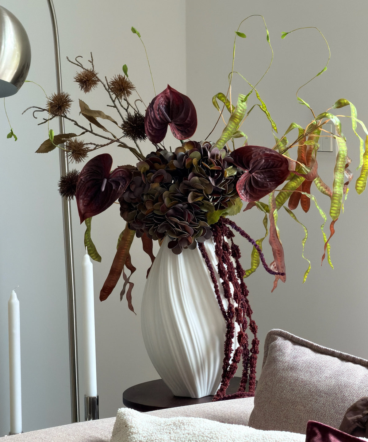 Kunstblumenstrauß Copper Dusk in Bordeaux, Grün & Kupfer aus der Serie Bloom – auf dem Sideboard neben dem Sofa