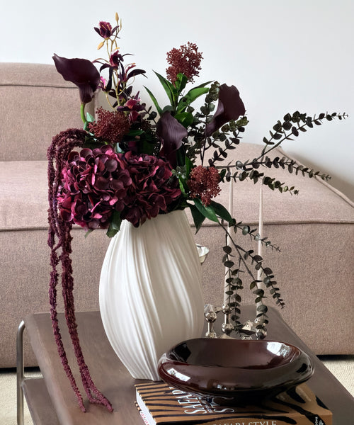 Kunstblumenstrauß Merlot Night in Bordeaux & Grün aus der Serie Bloom – auf dem Couchtisch im Wohnzimmer