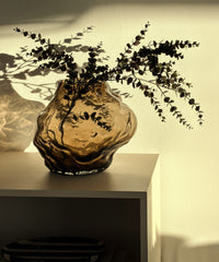 Suri Vase mit Eukalyptuszweigen auf dem Sideboard im Sonnenlicht