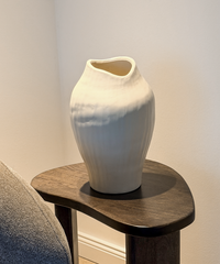 Große Maira Vase auf einem dunklen Beistelltisch neben dem Sessel